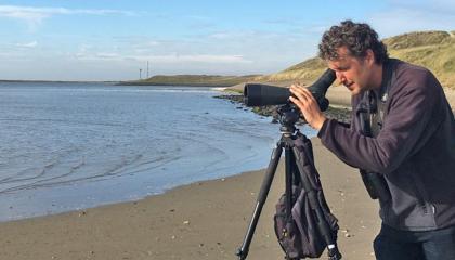Vincent Stork in actie. Op de achtergrond de Mokbaai, één van de belangrijke wadvogelgebieden op Texel.